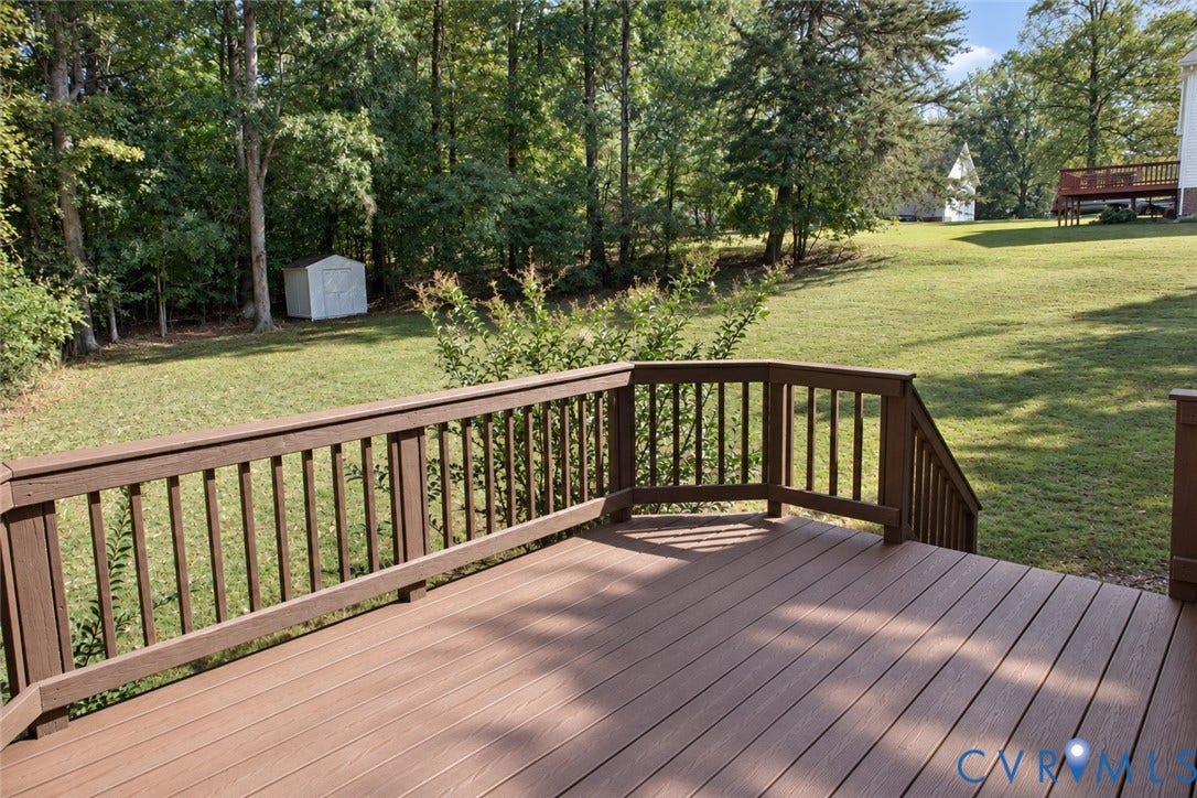 4229 Cedar Creek Lane, Prince George, VA 23875 Elevated wood-finish deck with railings, expansive lawn, and mature perimeter trees