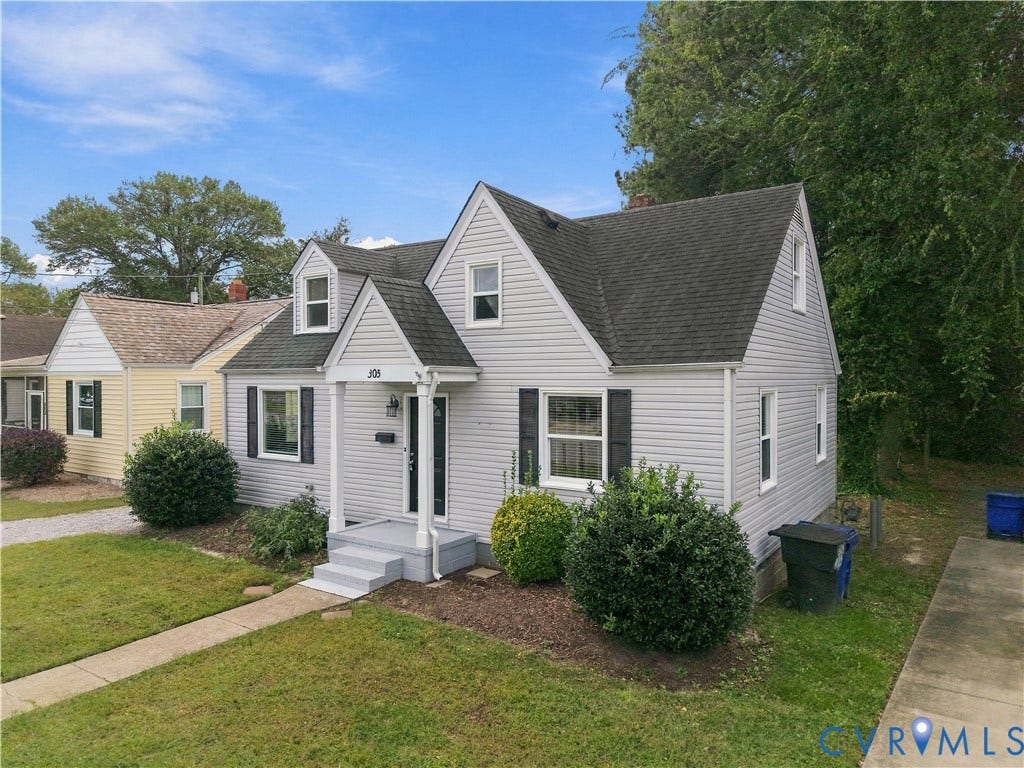 305 Arizona Street, Kingman Heights, Portsmouth, VA 23701 Cape Cod-style residence featuring light gray vinyl siding, a steep-pitched roof with prominent gables, decorative window shutters, and a covered front entryway
