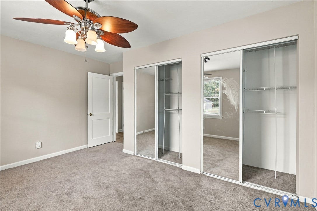 305 Arizona Street, Kingman Heights, Portsmouth, VA 23701 Room featuring neutral-toned carpeting, dual closets with sliding mirrored doors, and a ceiling fan with integrated multi-light fixture
