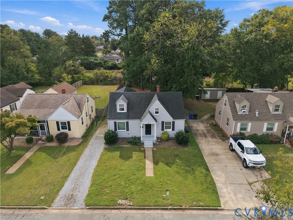 305 Arizona Street, Kingman Heights, Portsmouth, VA 23701 Cape Cod-style residence featuring a grey siding exterior, a dark shingled roof, two dormer windows, and a covered front entryway
