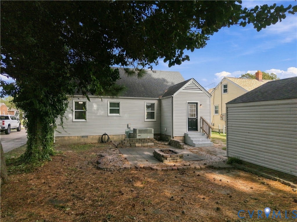 305 Arizona Street, Kingman Heights, Portsmouth, VA 23701 Exterior featuring light-toned vinyl siding, a paver patio, a built-in stone fire pit, and a detached structure