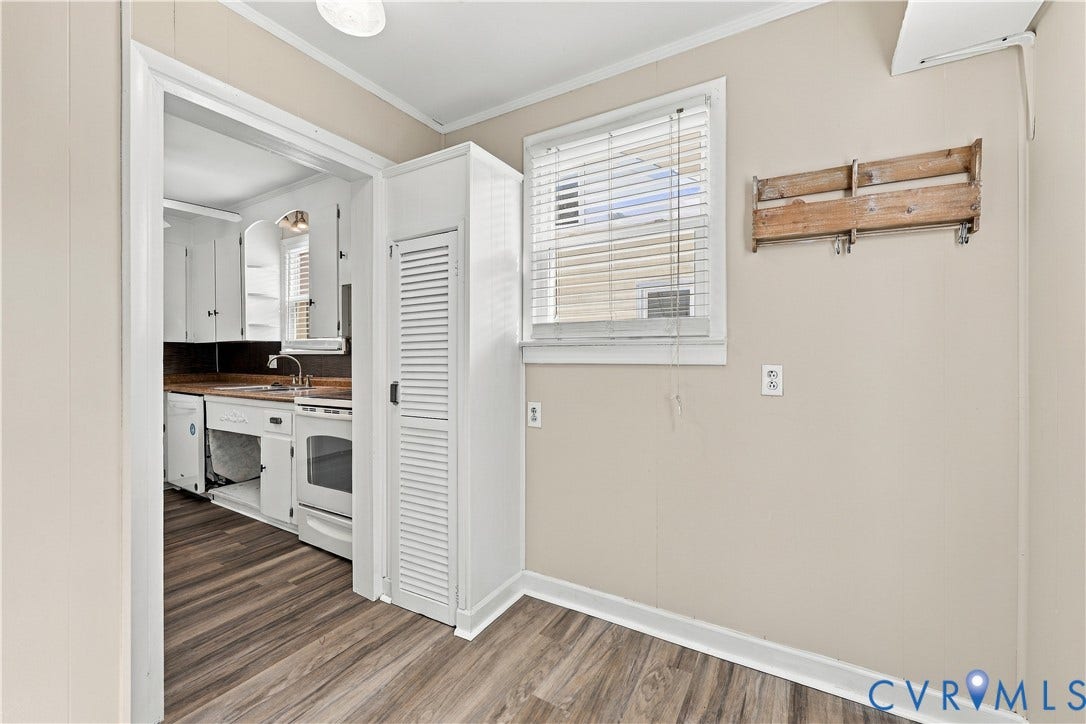 305 Arizona Street, Kingman Heights, Portsmouth, VA 23701 Wood-finish flooring, white louvered pantry cabinet, and double-hung window with blinds