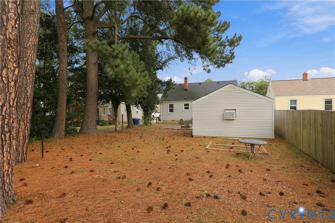 305 Arizona Street, Kingman Heights, Portsmouth, VA 23701 Spacious backyard featuring mature trees, detached garage, and wood-paneled privacy fencing