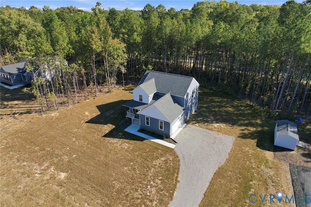 8209 Grantham Woods Way, Grantham Woods, Henrico, VA 23231 Two-story residence featuring grey lap siding, a shingled roof, a gravel driveway, and a detached storage shed on a wooded lot
