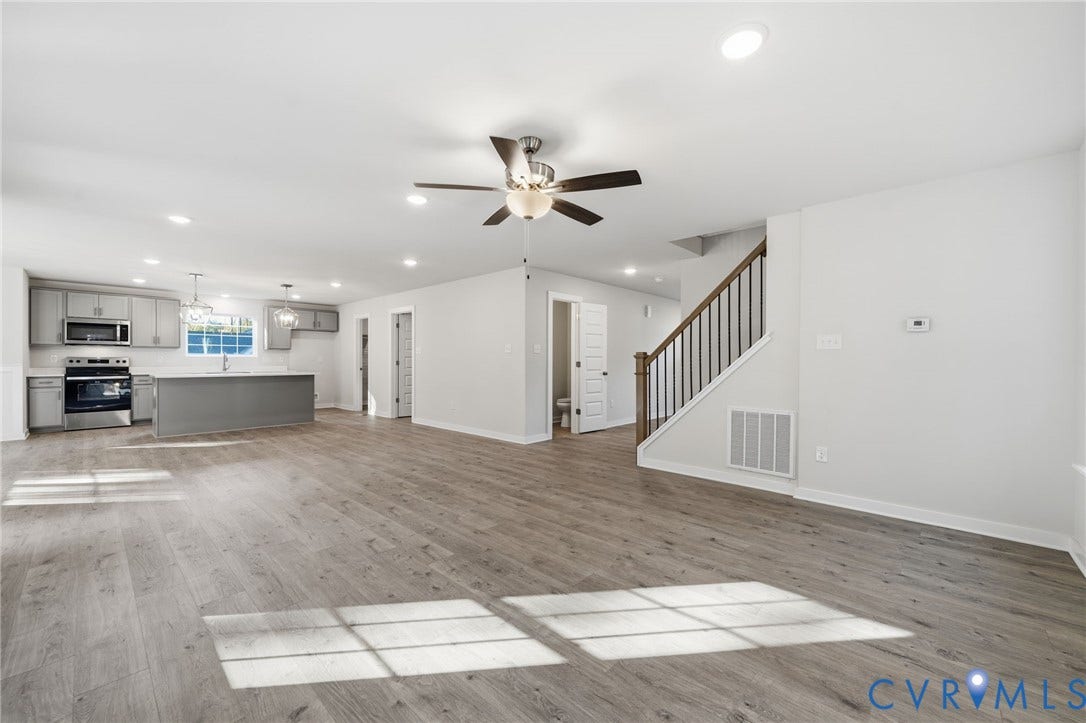 8209 Grantham Woods Way, Grantham Woods, Henrico, VA 23231 Open concept interior featuring wood-finish flooring, recessed lighting, a ceiling fan, and a kitchen equipped with cabinetry, a central island, and stainless-steel appliances