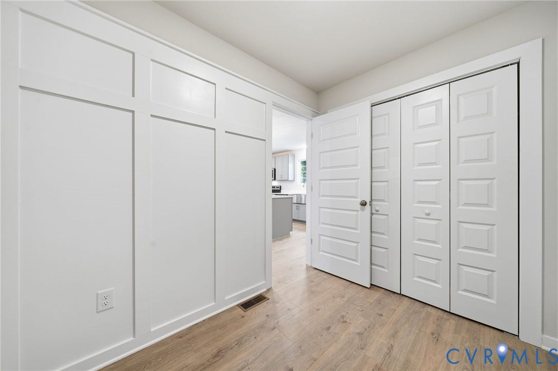 8209 Grantham Woods Way, Grantham Woods, Henrico, VA 23231 Wall with custom board-and-batten millwork, wood-finish flooring, and multi-panel interior doors
