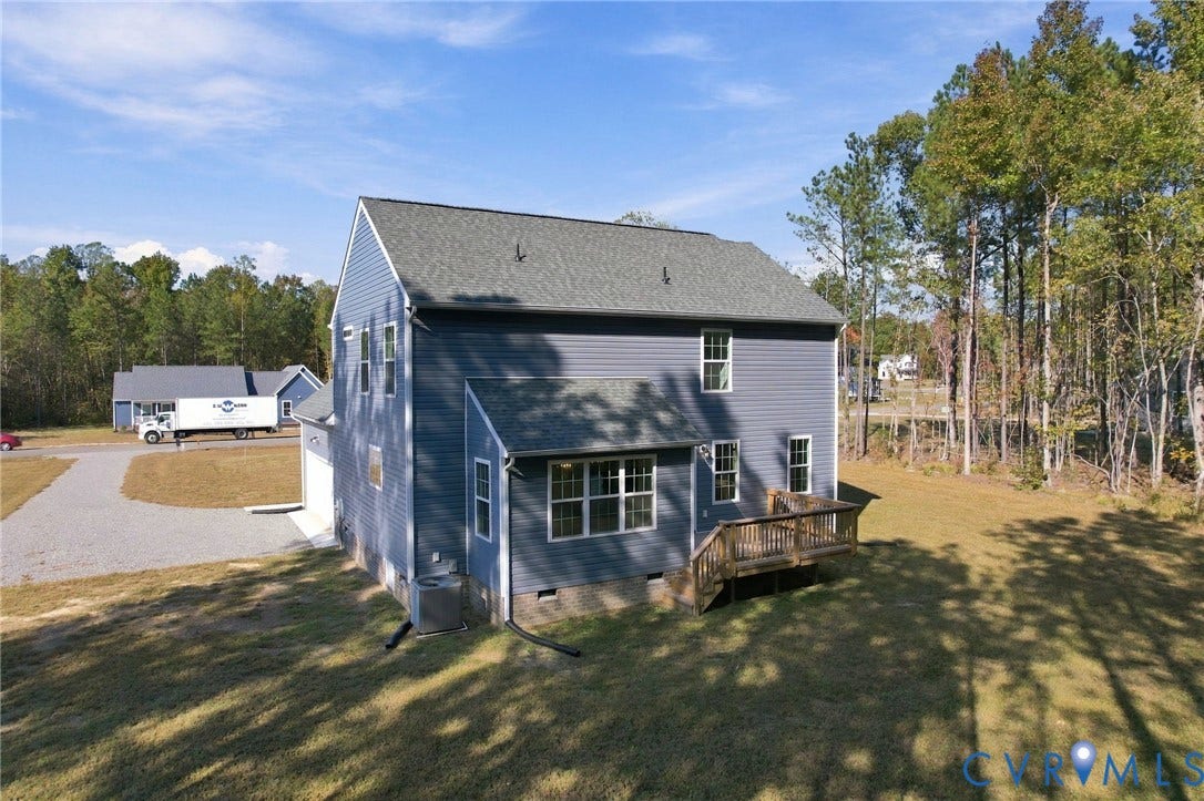 8209 Grantham Woods Way, Grantham Woods, Henrico, VA 23231 Two-story exterior featuring blue vinyl siding, an asphalt shingle roof, a rear wood deck, and a gravel driveway