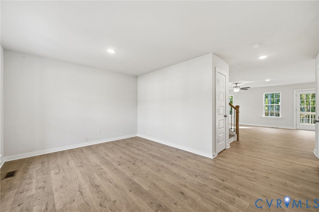 8209 Grantham Woods Way, Grantham Woods, Henrico, VA 23231 Neutral-toned interior space featuring wood-finish flooring, recessed lighting, multi-panel interior doors, and grid-pattern window panes