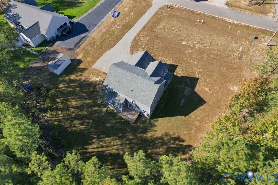 8209 Grantham Woods Way, Grantham Woods, Henrico, VA 23231 Aerial perspective of a detached residence featuring a multi-gable roofline, attached wooden deck, gravel driveway, and a partially wooded lot