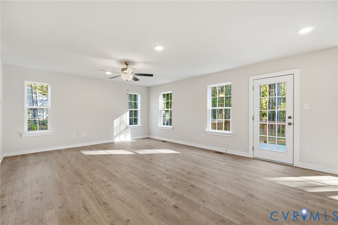 8209 Grantham Woods Way, Grantham Woods, Henrico, VA 23231 Open interior space featuring wood-finish flooring, recessed lighting, a ceiling fan with integrated light fixture, multiple multi-pane windows, and a glass-panel exterior door