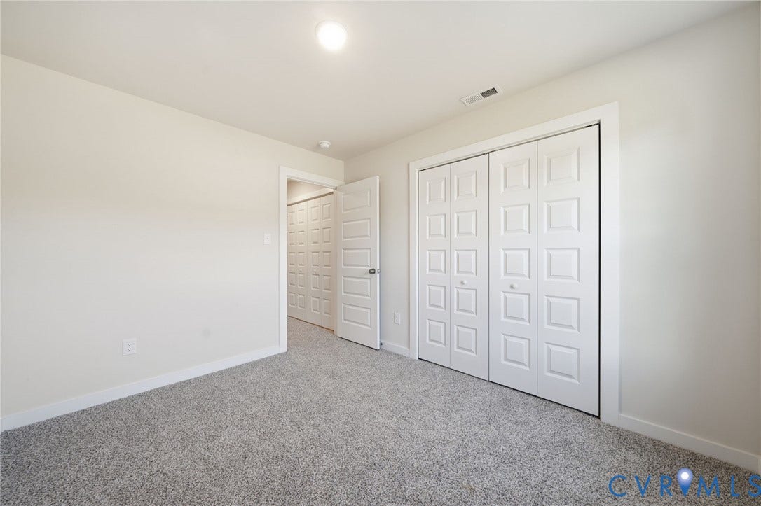 8209 Grantham Woods Way, Grantham Woods, Henrico, VA 23231 Neutral-toned carpeted flooring, white interior walls, and bi-fold closet doors with raised-panel detailing