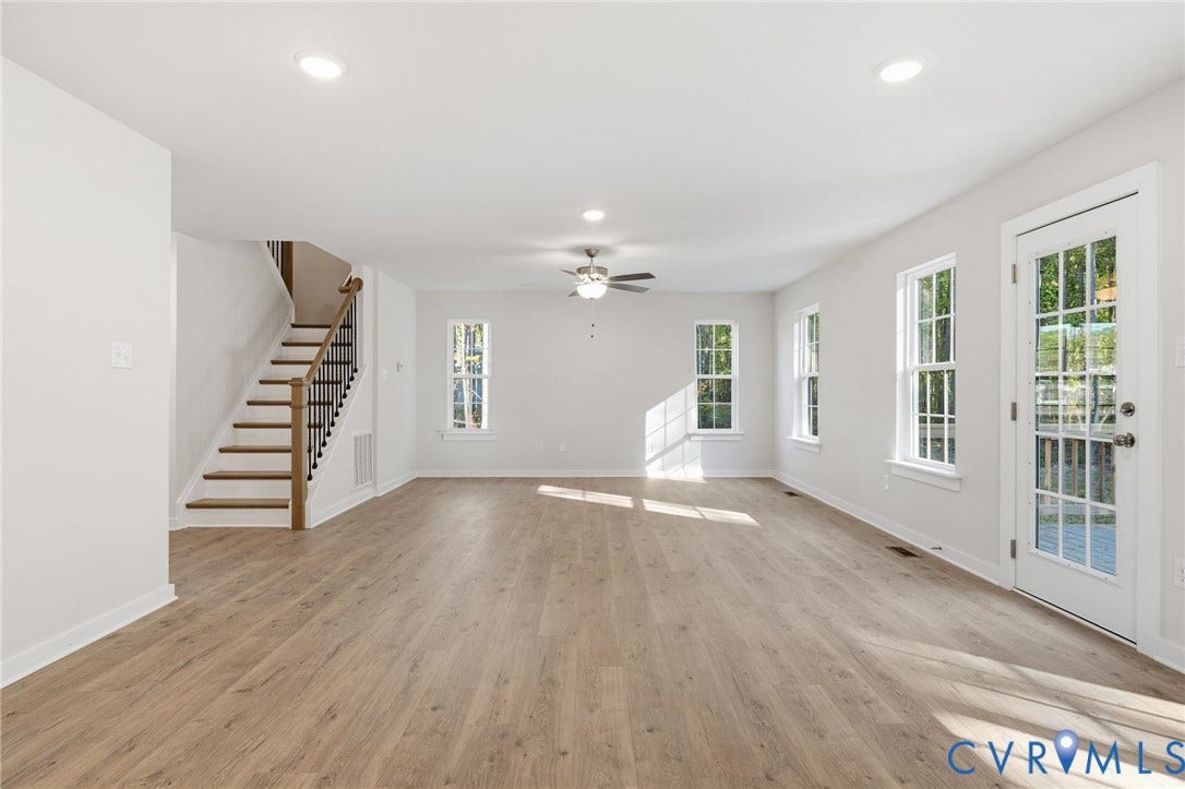 8209 Grantham Woods Way, Grantham Woods, Henrico, VA 23231 Open floor plan featuring wood-finish flooring, recessed lighting, ceiling fan, staircase with metal balusters, and a glass-paneled exterior door