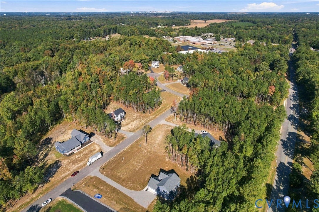 8209 Grantham Woods Way, Grantham Woods, Henrico, VA 23231 Aerial perspective of a residential development featuring paved streets, asphalt driveways, and expansive wooded surroundings