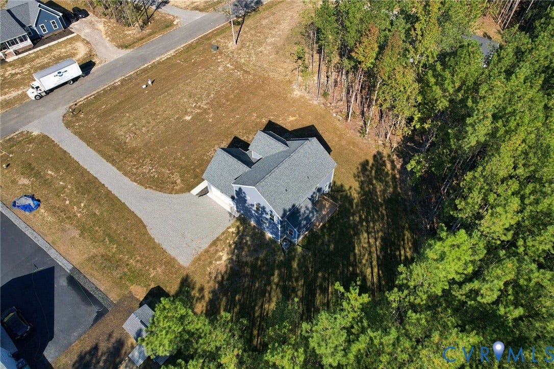 8209 Grantham Woods Way, Grantham Woods, Henrico, VA 23231 Aerial perspective of a detached residence featuring a multi-gabled roofline, light-colored siding, a gravel driveway, and a partially wooded lot