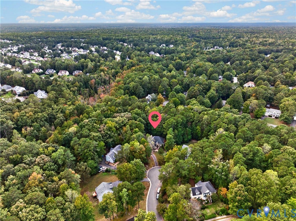 Aerial perspective of a property lot characterized by mature tree canopy and dense perimeter foliage situated at the terminus of a cul-de-sac