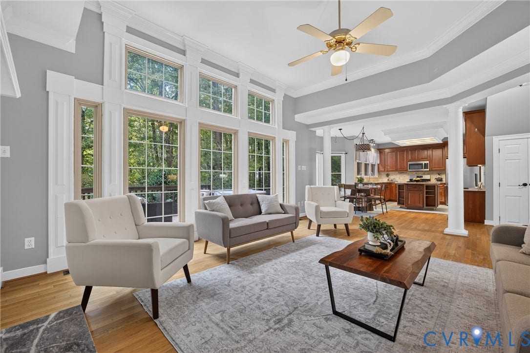 Vaulted ceilings with crown molding, floor-to-ceiling windows with mullions, wood-finish flooring, and classical architectural columns