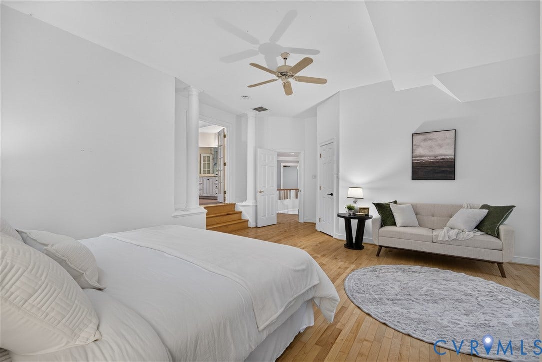 Room featuring wood-finish flooring, ceiling fan, and decorative columns