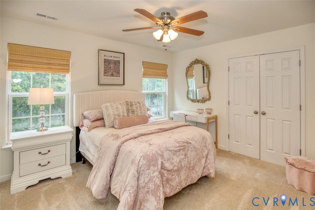 13501 Cooks Mill Court, Cooks Mill, Lanexa, VA 23089 Neutral carpeted flooring, dual-window configuration, wood-finish ceiling fan with integrated lighting, and white paneled double-door closet