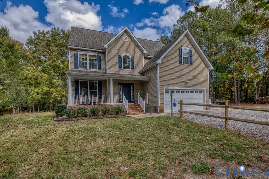 13501 Cooks Mill Court, Cooks Mill, Lanexa, VA 23089 Two-story residence featuring horizontal siding, a covered front porch with white railing, brick-accented entryway, attached two-car garage, and wooden split-rail fencing