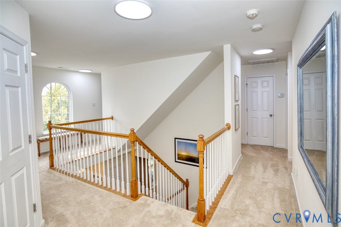 13501 Cooks Mill Court, Cooks Mill, Lanexa, VA 23089 Landing area featuring wall-to-wall carpeting, wood-finish handrails, white balusters, recessed lighting, and an arched window