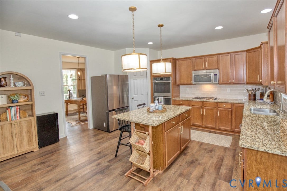 13501 Cooks Mill Court, Cooks Mill, Lanexa, VA 23089 Kitchen featuring wood cabinetry, stone-finish countertops, stainless steel appliances, a central island, and wood-finish flooring