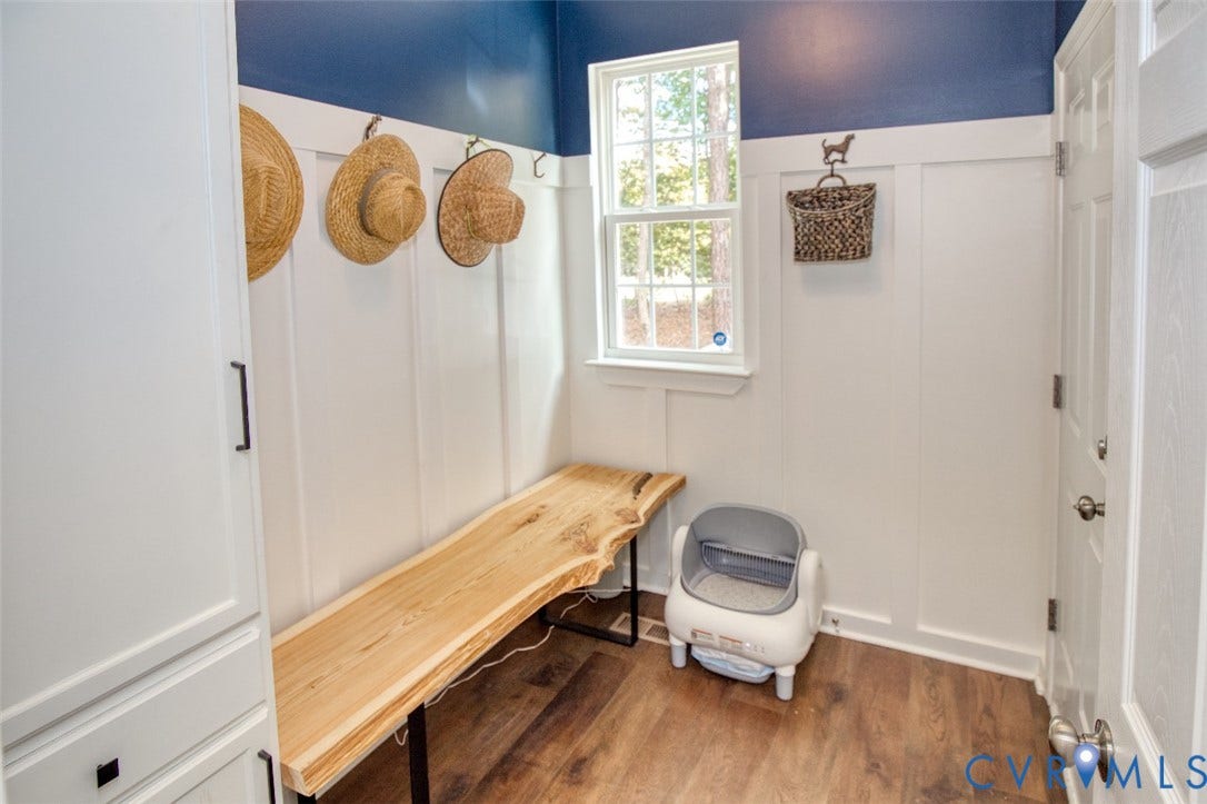 13501 Cooks Mill Court, Cooks Mill, Lanexa, VA 23089 Mudroom area featuring white vertical wall paneling, built-in cabinetry, wood-finish flooring, and a live-edge wood bench with a metal frame