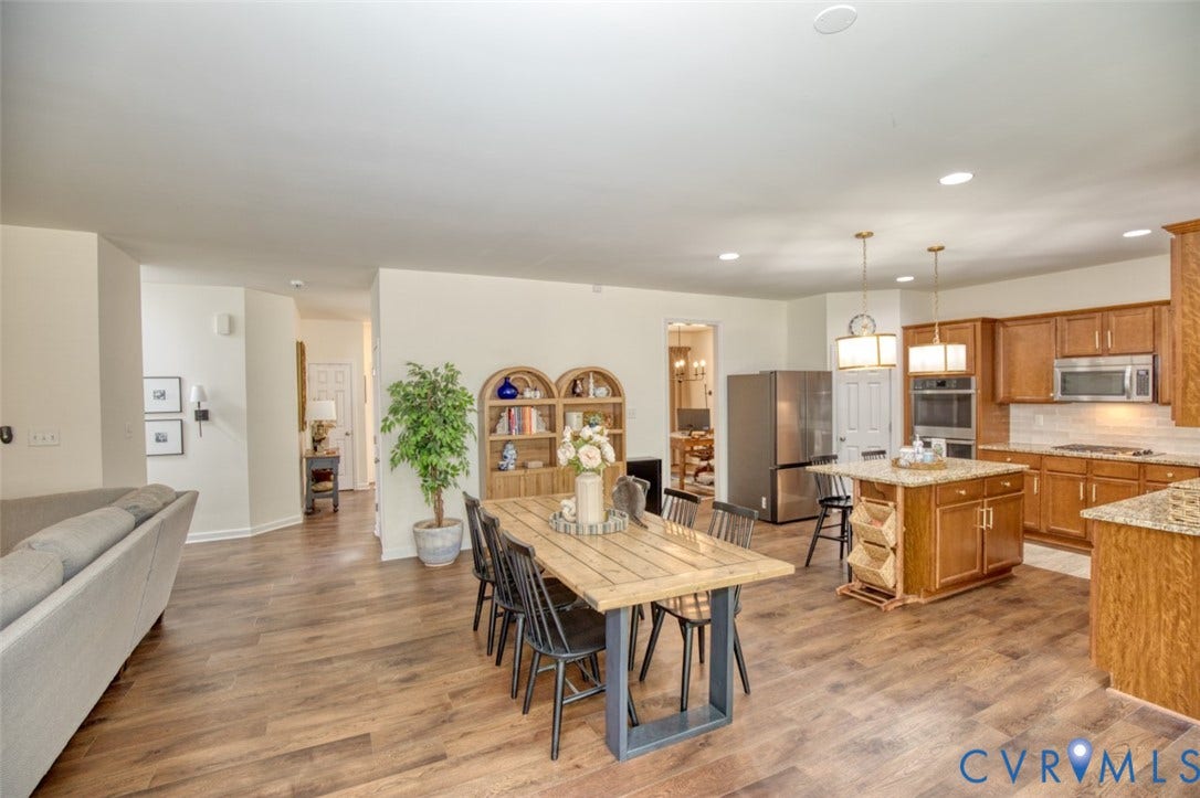 13501 Cooks Mill Court, Cooks Mill, Lanexa, VA 23089 Kitchen featuring wood cabinetry, stone countertops, a center island with pendant lighting, and stainless steel appliances, all set over wood-finish flooring