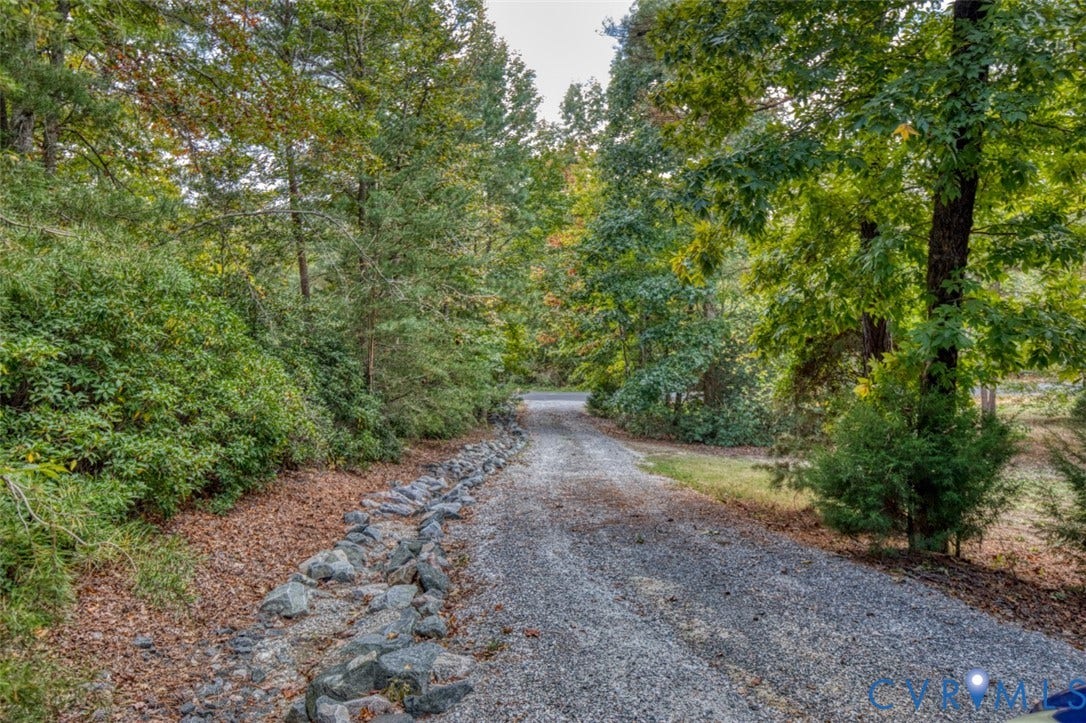 13501 Cooks Mill Court, Cooks Mill, Lanexa, VA 23089 Gravel driveway bordered by stone landscaping and mature wooded foliage