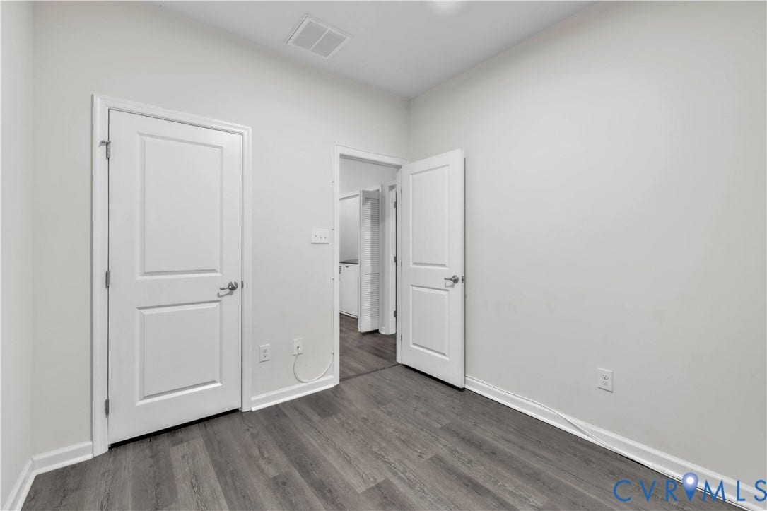 4511 Wistar Woods Trail, Richmond, VA 23228 Neutral-toned interior featuring wood-finish flooring, two-panel interior doors with metallic hardware, and smooth-finish walls