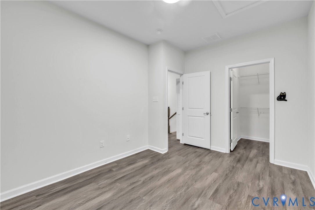 4511 Wistar Woods Trail, Richmond, VA 23228 Room with neutral wall tones, wood-finish flooring, and a walk-in closet featuring built-in wire shelving