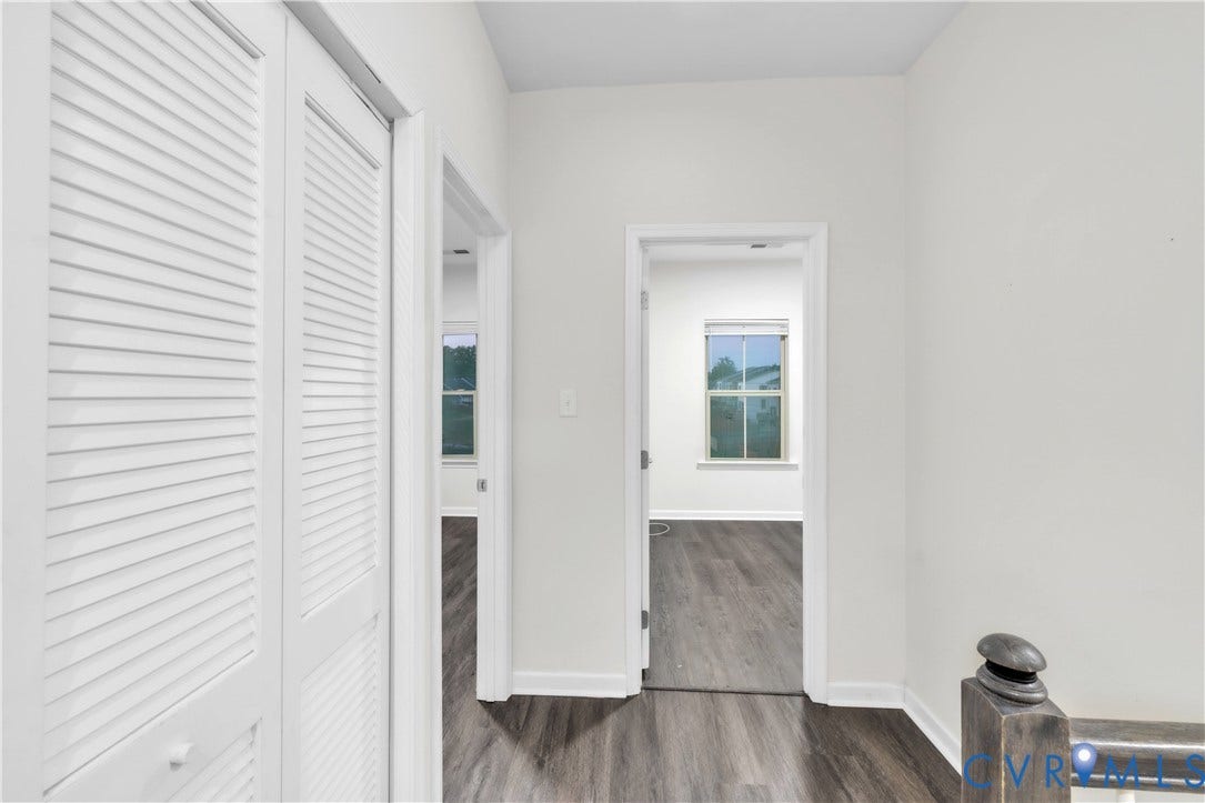 4511 Wistar Woods Trail, Richmond, VA 23228 Hallway featuring wood-finish flooring, white louvered closet doors, and dark-toned baluster