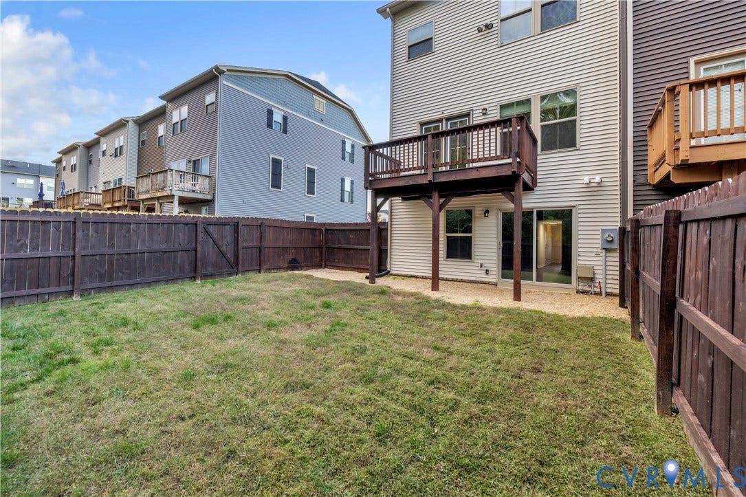 4511 Wistar Woods Trail, Richmond, VA 23228 Rear yard featuring a grass lawn, gravel patio area, elevated wood deck, and wood privacy fencing