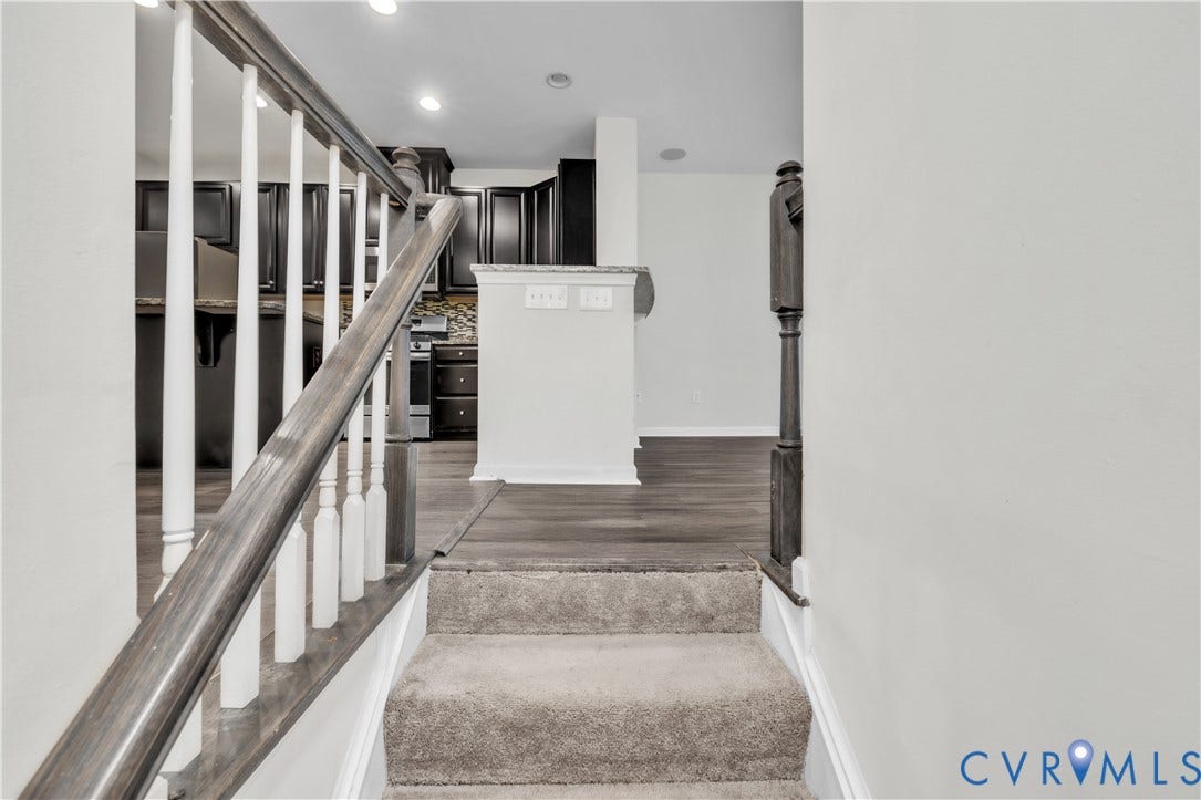 4511 Wistar Woods Trail, Richmond, VA 23228 Staircase featuring carpeted treads, wood-finish handrail, and white balusters