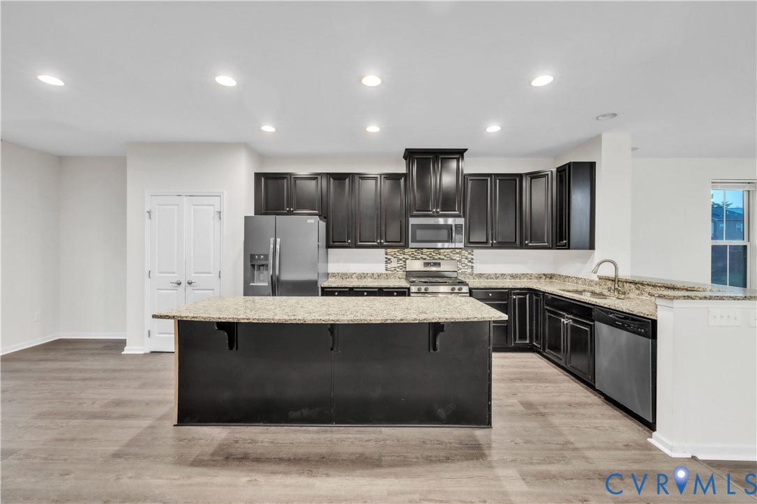 4511 Wistar Woods Trail, Richmond, VA 23228 Kitchen featuring dark-finish cabinetry, stone-surface countertops, center island, recessed lighting, and wood-finish flooring