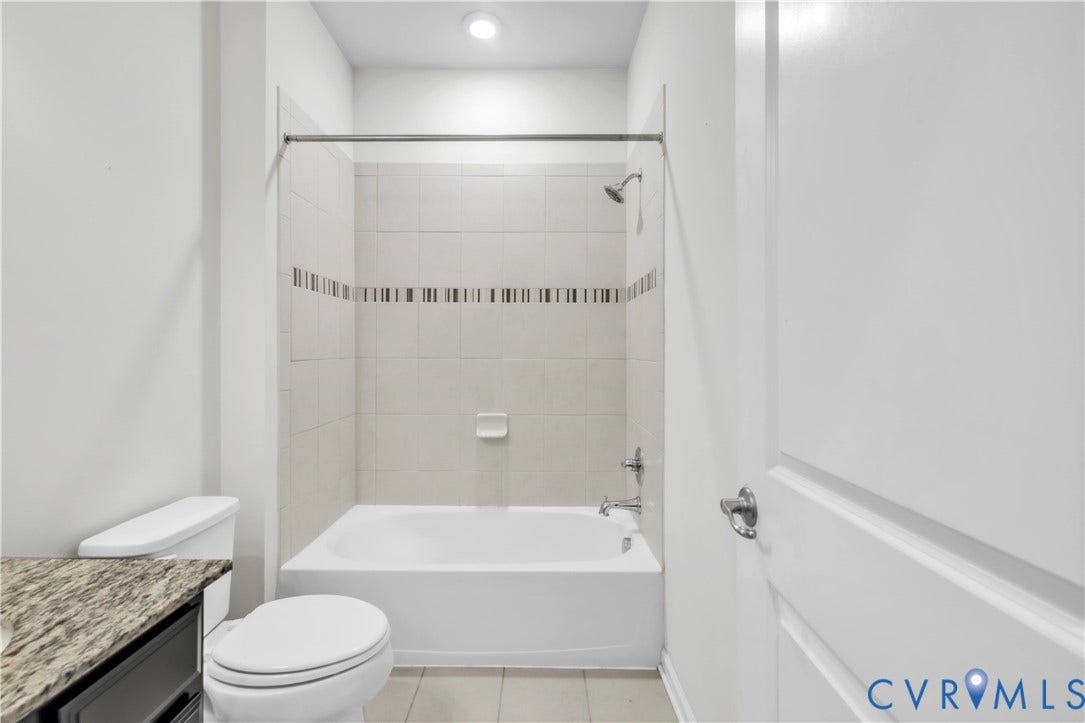 4511 Wistar Woods Trail, Richmond, VA 23228 Bathroom featuring a tub and shower combination with tiled surround, decorative mosaic accent tile, stone-finish vanity countertop, and chrome fixtures