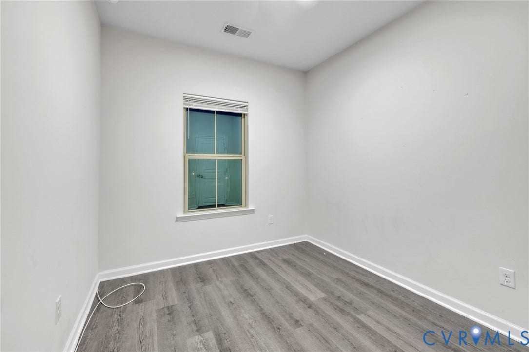 4511 Wistar Woods Trail, Richmond, VA 23228 Interior space featuring wood-finish flooring, white walls, and a single-pane window with white horizontal blinds