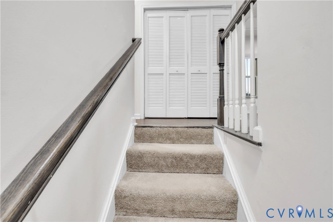 4511 Wistar Woods Trail, Richmond, VA 23228 Staircase featuring wall-to-wall carpeting, dark-stained wood handrails, white wood balusters, and a four-panel louvered closet door