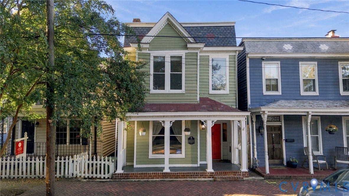 522 N 27th Street, Church Hill, Richmond, VA 23223 Historic architectural exterior featuring sage-colored siding, a covered front porch with decorative gingerbread trim, a brick-foundation stoop, and a gabled roofline