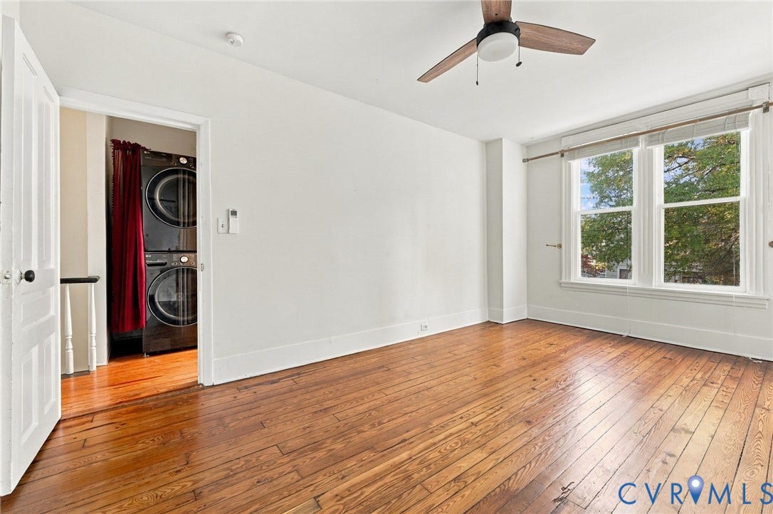 522 N 27th Street, Church Hill, Richmond, VA 23223 Front bedroom #2featuring wood-finish flooring, a ceiling-mounted fan with light fixture, double-pane windows, and a laundry area equipped with a stacked washer and dryer set