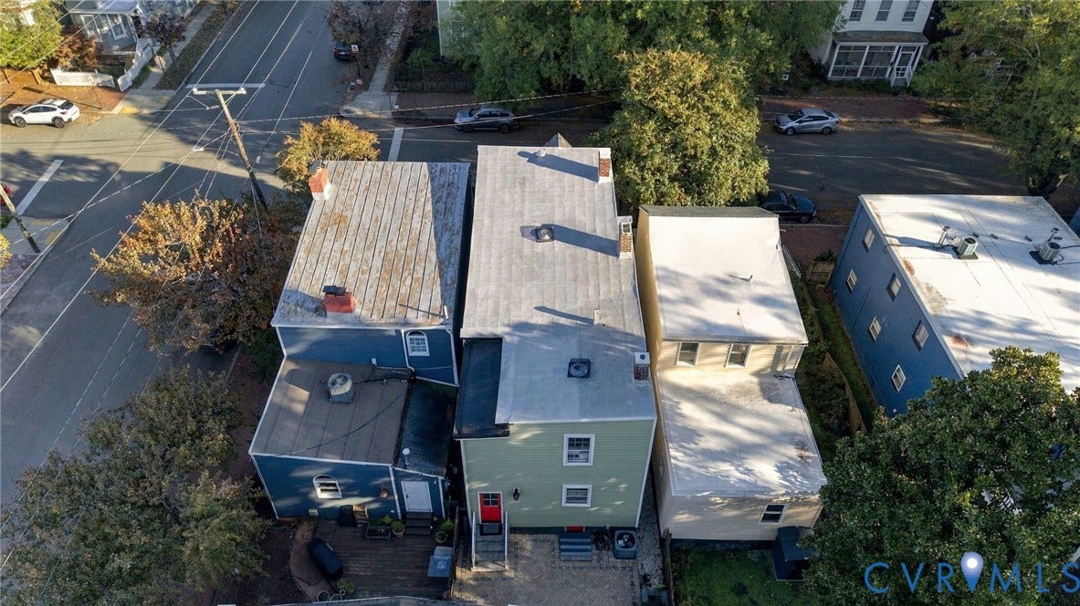 522 N 27th Street, Church Hill, Richmond, VA 23223 Aerial perspective of the property featuring a multi-level exterior, light green siding, a detached wood deck, and an off-street gravel parking area