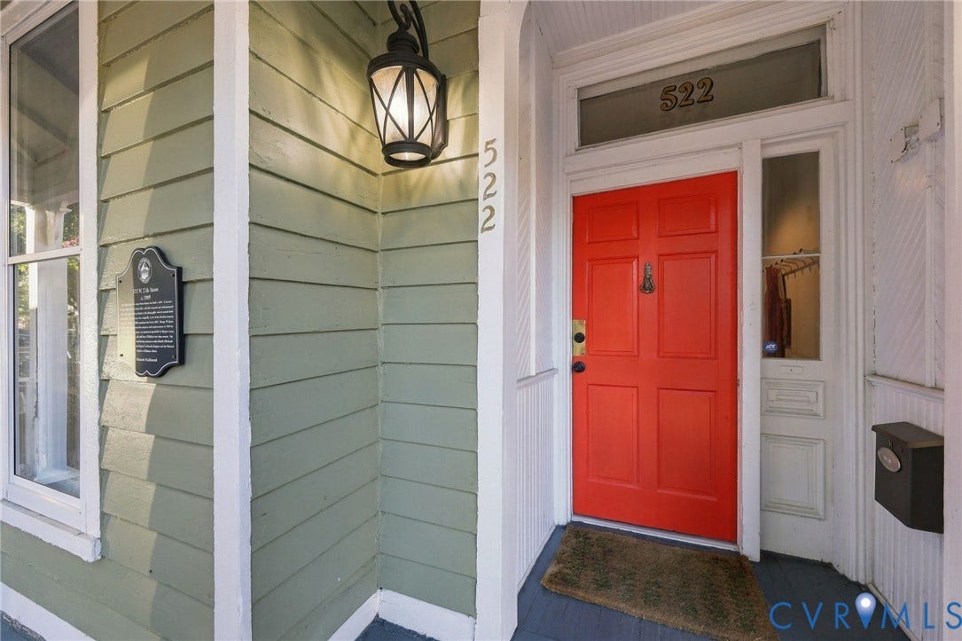 522 N 27th Street, Church Hill, Richmond, VA 23223 Exterior entry featuring horizontal lap siding, a paneled door with glass transom, sidelight with built-in mail slot, and an attached decorative wall-mounted lantern