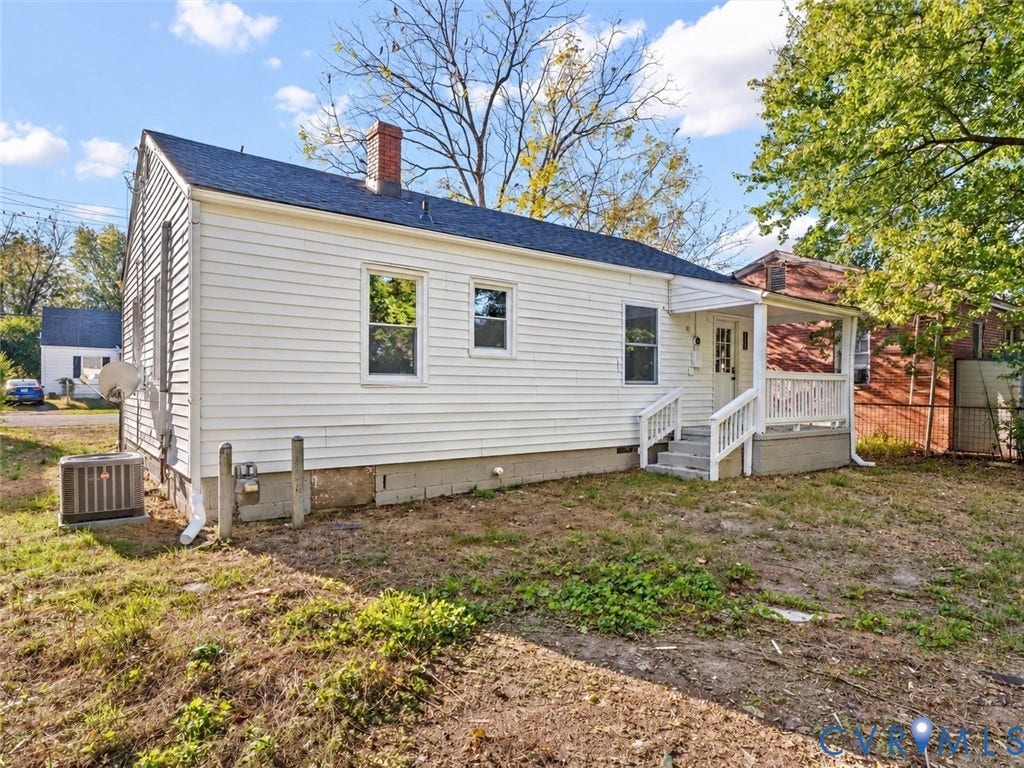 135 Elm Street, Petersburg, VA 23803 Single-story residence featuring white siding, an asphalt shingle roof with a brick chimney, and a covered front porch with white railing