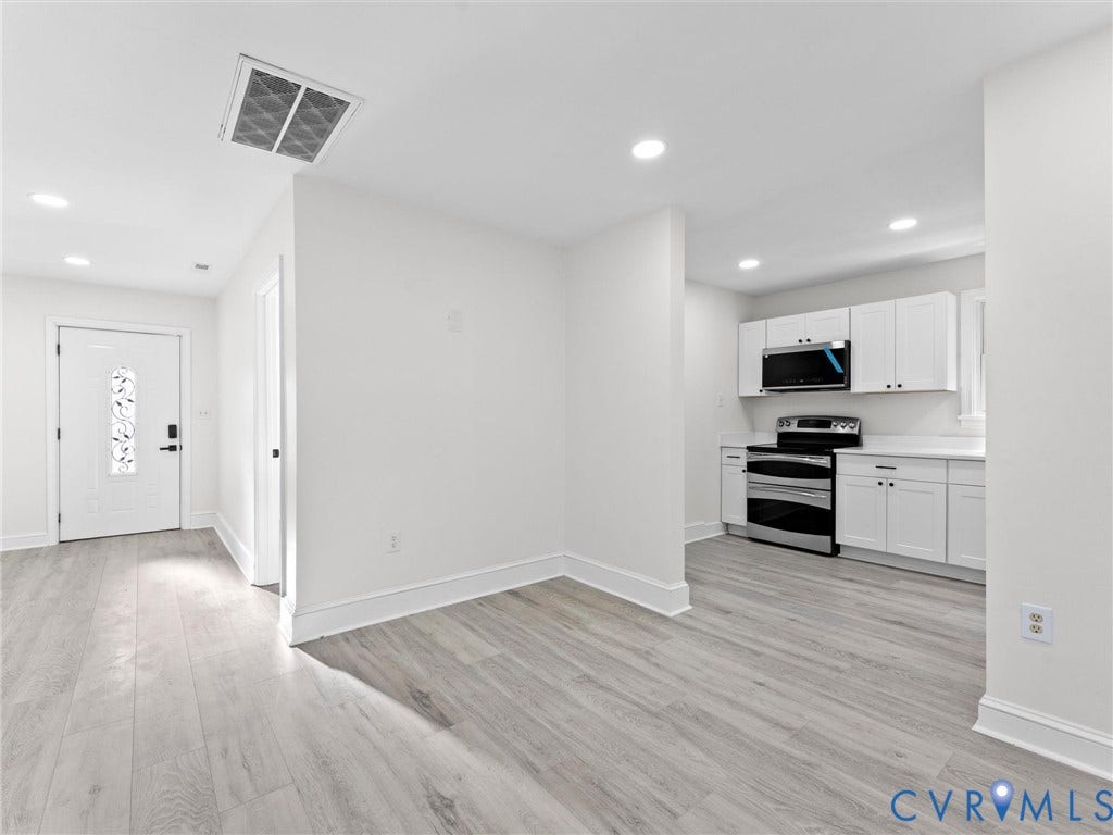 135 Elm Street, Petersburg, VA 23803 Kitchen featuring white shaker-style cabinetry, stainless steel appliances, and solid surface countertops, finished with wood-finish flooring and recessed lighting