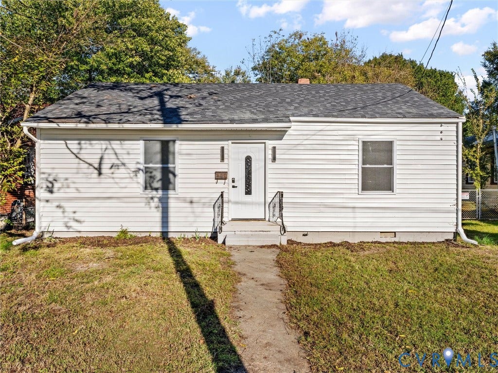 135 Elm Street, Petersburg, VA 23803 Single-story exterior featuring white horizontal siding, a gabled roof with asphalt shingles, a central entry door with decorative glass paneling, and wrought iron handrails