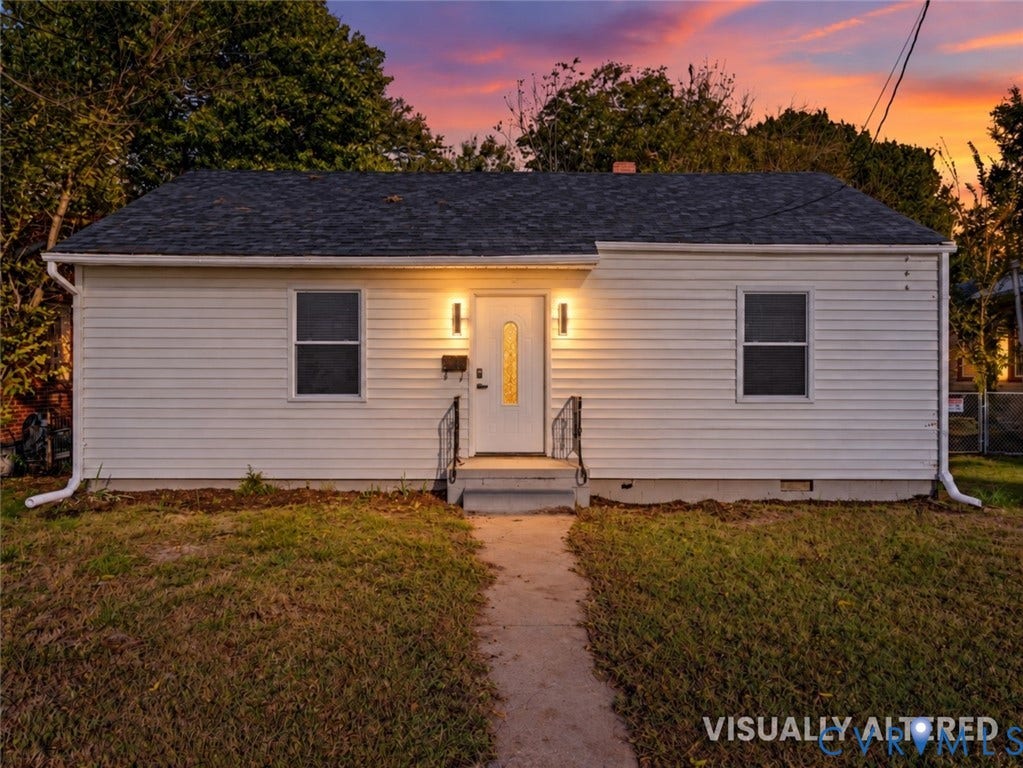135 Elm Street, Petersburg, VA 23803 Single-story exterior featuring white horizontal siding, a dark shingle roof, a central front door with a decorative glass insert, and metal handrails