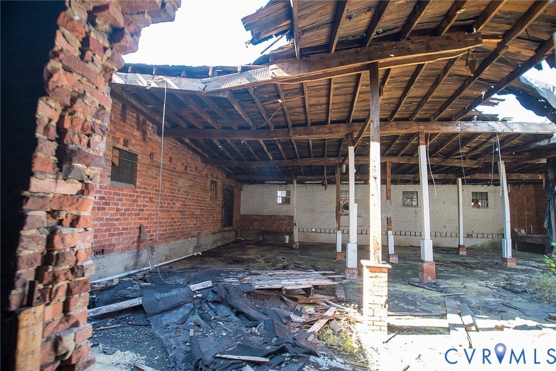 109 E Oak Street, Covington, VA 24426 Open-concept structure featuring exposed brick masonry walls, heavy timber roof beams, and vertical wood support columns
