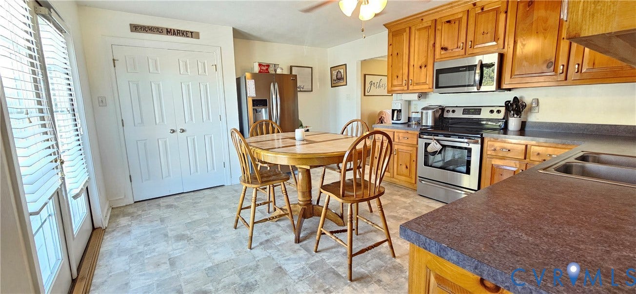 8605 Howerton Road, Center Cross, VA 22437 Kitchen featuring natural wood cabinetry, stainless steel appliances, solid-surface countertops, dual-basin stainless steel sink, and glass-paneled double doors