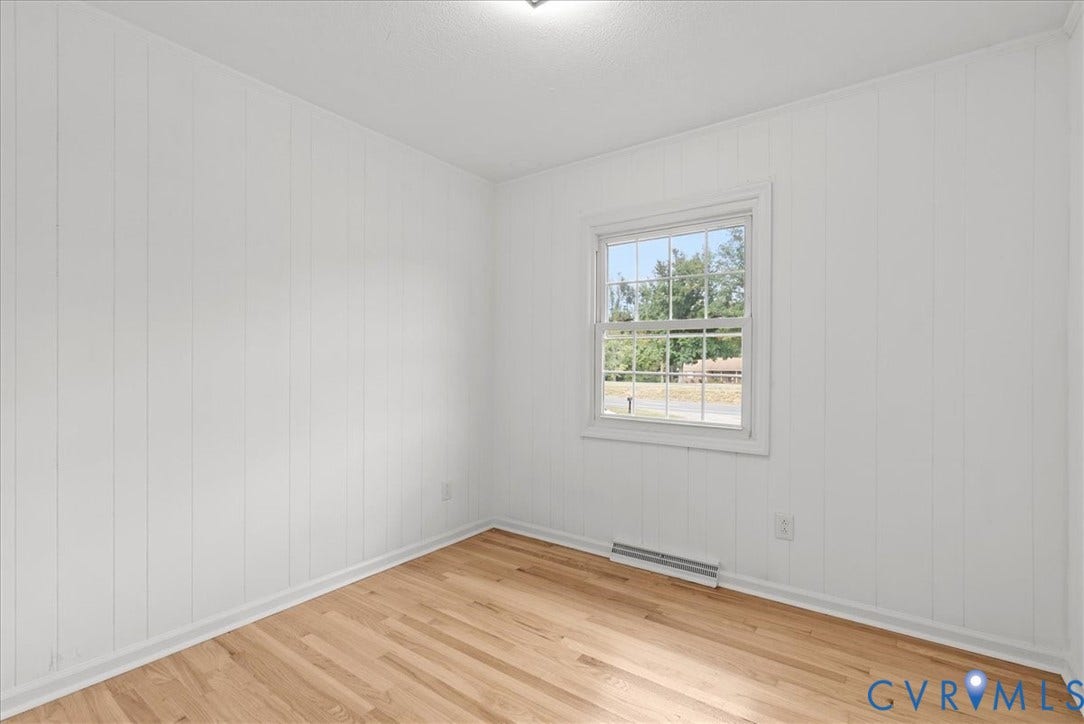 4942 Pleasant Shade Drive, Emporia, Emporia, VA 23847 Interior room featuring vertical wood paneling, wood-finish flooring, and a single-hung window with muntin detailing