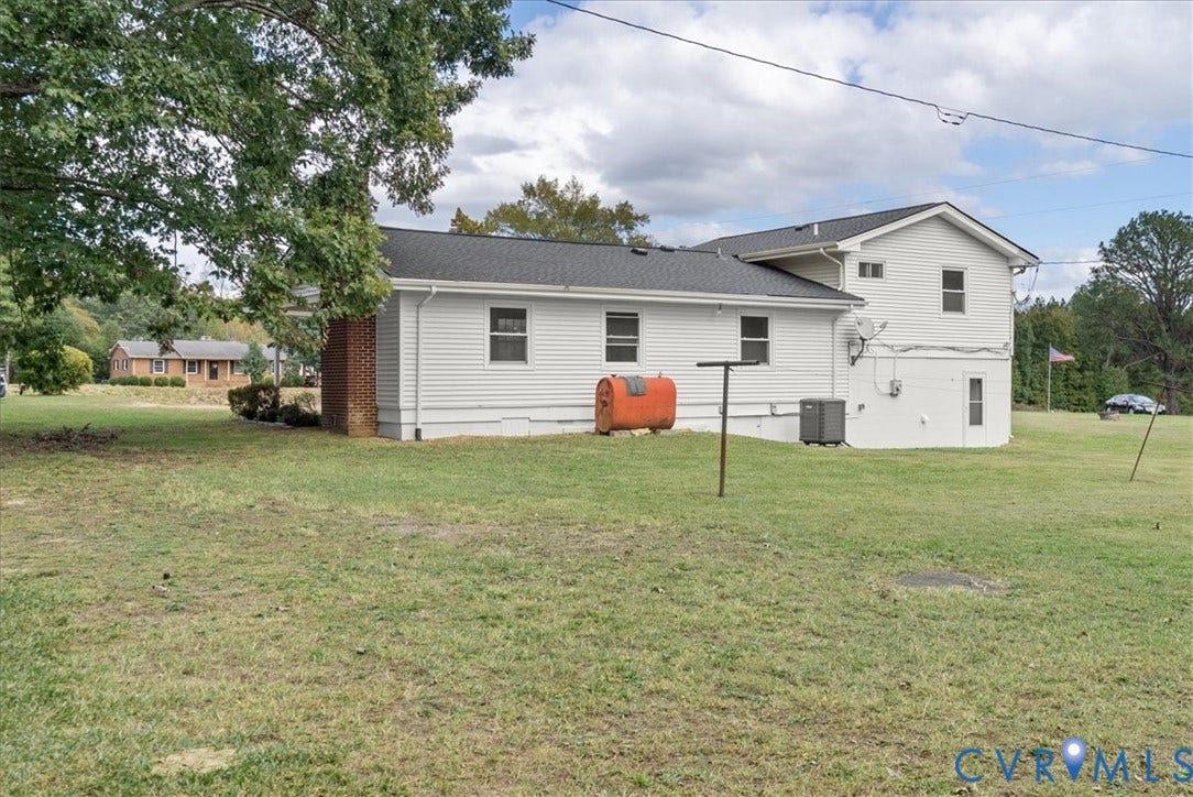 4942 Pleasant Shade Drive, Emporia, Emporia, VA 23847 Exterior featuring light-colored horizontal siding, a dark shingled roof, a brick chimney, and expansive open grounds