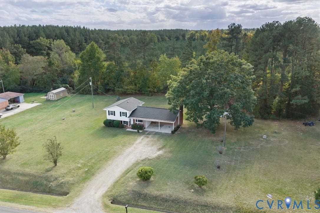 4942 Pleasant Shade Drive, Emporia, Emporia, VA 23847 Multi-level home featuring an attached carport, light-toned exterior siding, a shingled roof, a detached storage structure, and expansive grounds with mature trees